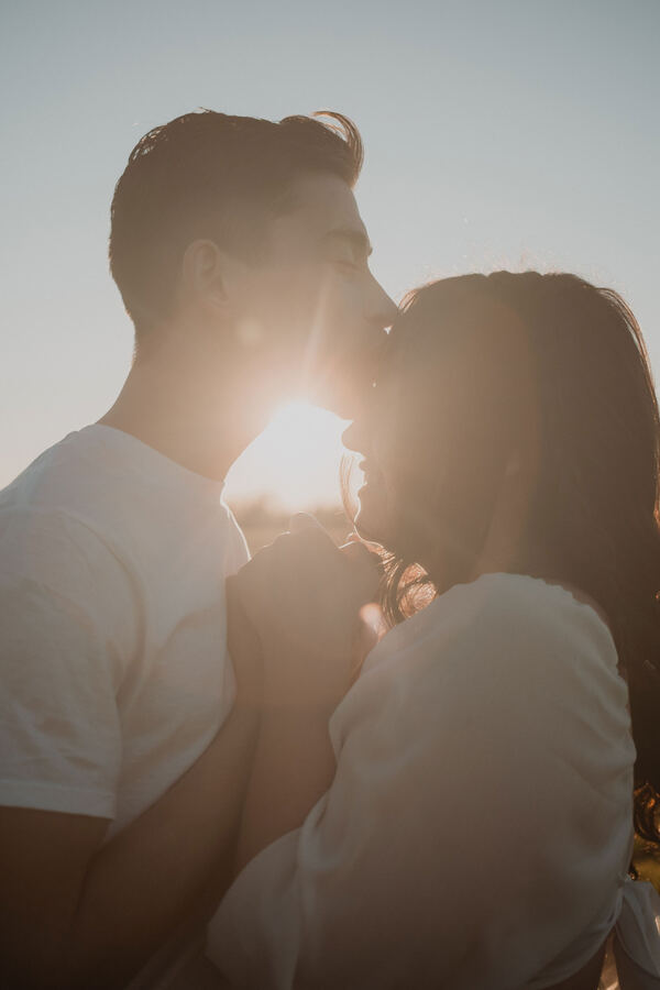 Silhouetted kiss with sun flare