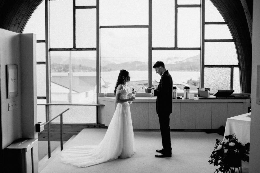 Bride and groom in a tall windowed venue