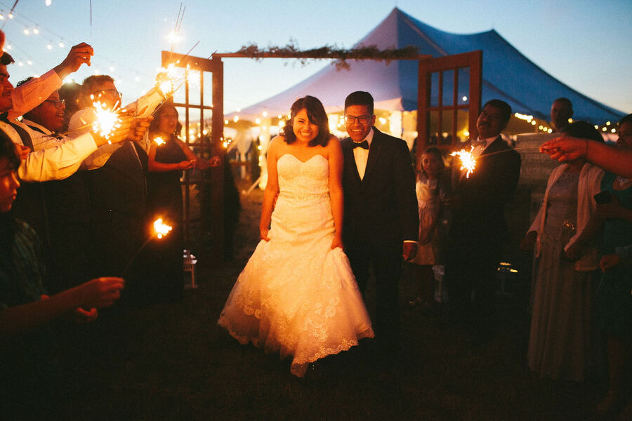Sparkler-lit dancing under a tent at night