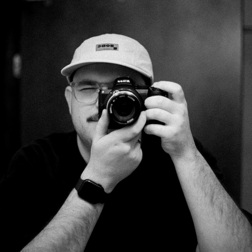 Steven George, holding a Nikon camera